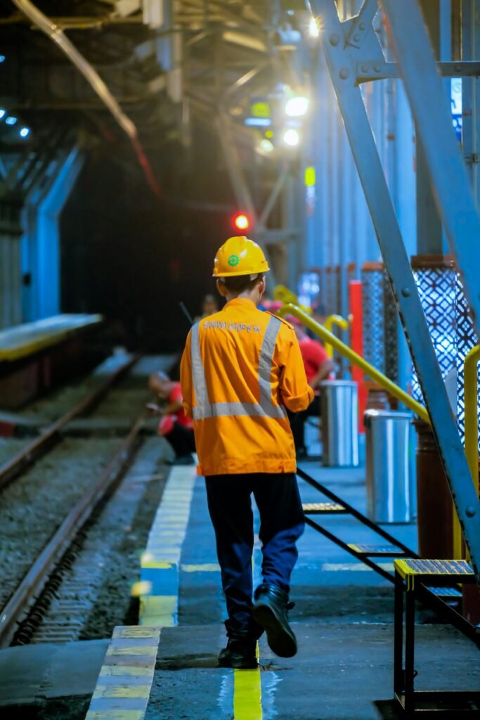 Railway worker in a hi-vis jacket walking along a railway track