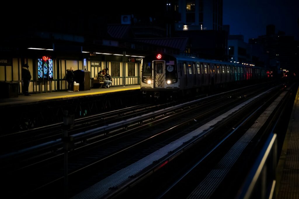 Train pulling into a railway station at night